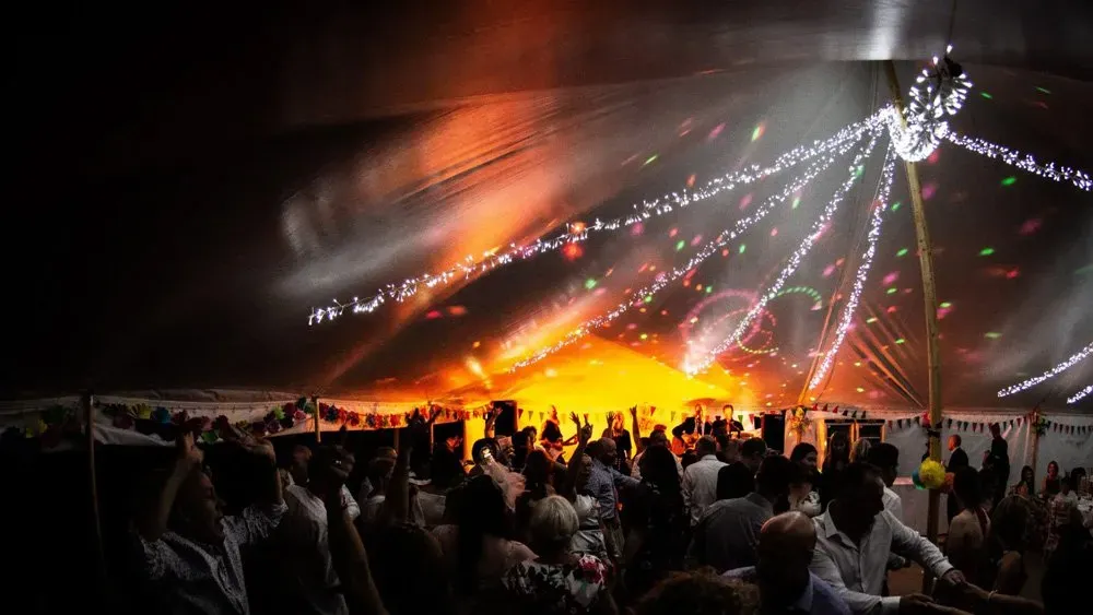 Timber dance floor under a marquee at night