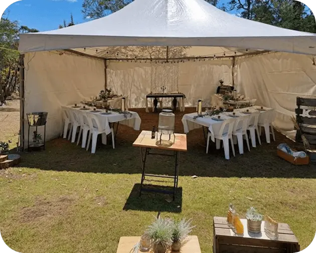 Open-sided free-standing marquee with tables set on a bush block