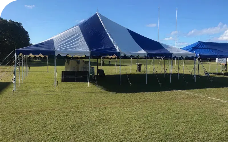 Big Blue and White striped peg-and-pole marquee on a sports oval