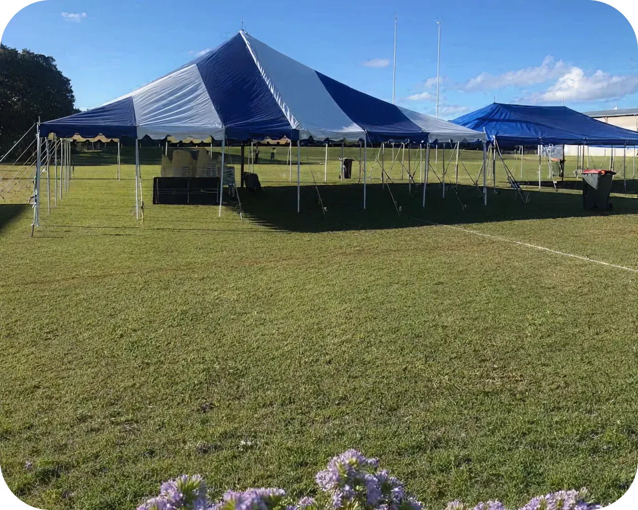 Blue and white striped marquee set up on a sports oval